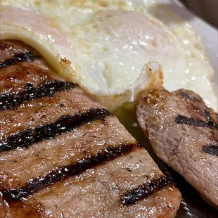 Pork chops grilled with over easy eggs