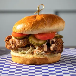 a chicken sandwich with pickles and tomatoes