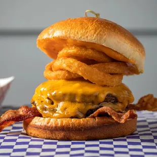 a cheeseburger with onion rings and bacon