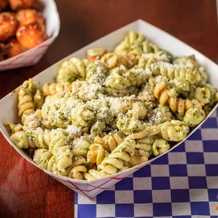 a bowl of pasta and a sandwich on a table