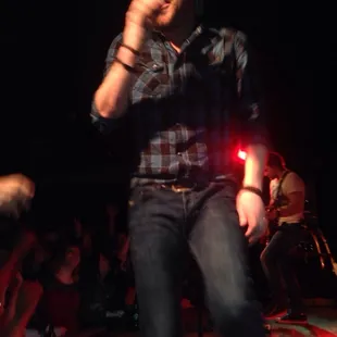 a man on stage singing into a microphone