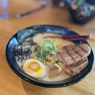 a bowl of ramen with chopsticks and an egg