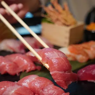 a close up of a sushi with chopsticks
