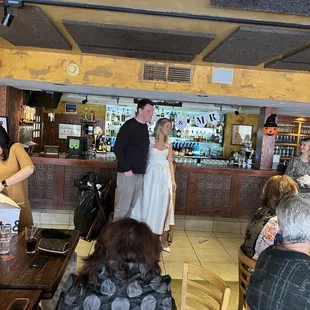 a man and a woman standing at a bar