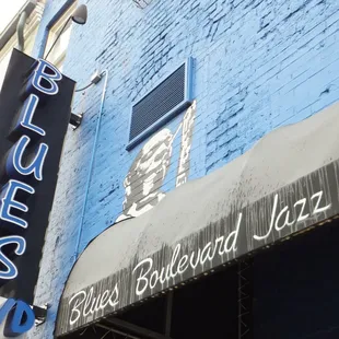 a blue building with a neon sign