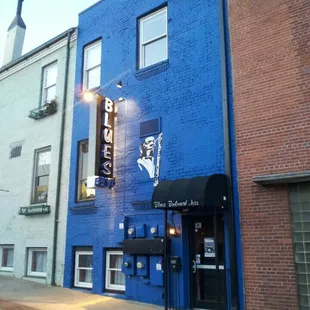 a blue building with a black awning