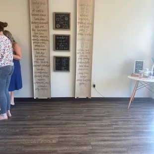 two women standing in front of a wall with menus on it