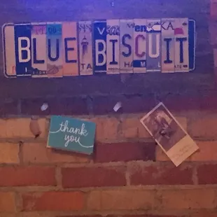 a blue biscuit sign on a brick wall