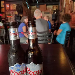two bottles of coors light on a table