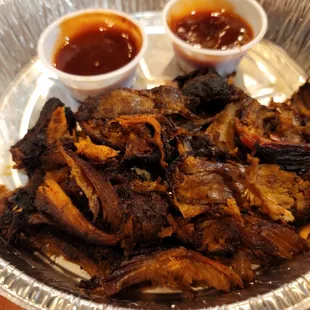 a plate of ribs and sauces