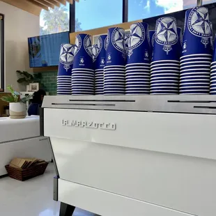 blue and white cups on a coffee machine