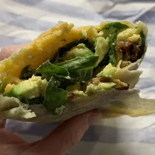 Breakfast burrito - eggs, bacon, cheese, spinach, avocado, and dill sauce