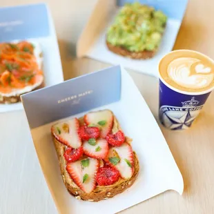 a sandwich with strawberries and a cup of coffee