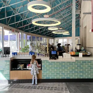 a little girl standing in front of a counter