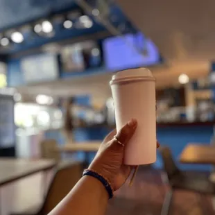 a hand holding a cup of coffee