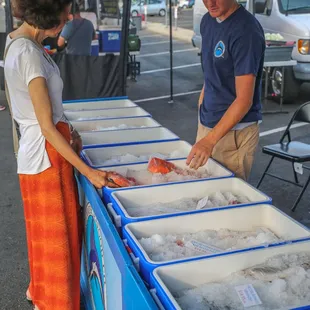 a man and a woman at a seafood stand