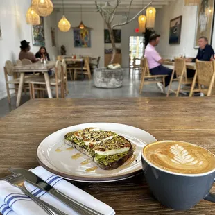 Sweet Halloumi - smashed avocado, lemon, pistachio dukkah and grilled halloumi, raw flower honey. $16. Regular hot latte.