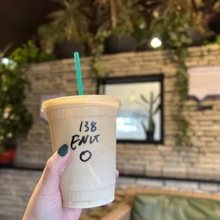 a hand holding a cup of iced coffee