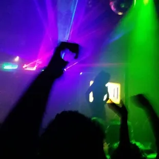 a person holding up a cell phone at a concert