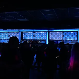 a group of people standing in front of a bar