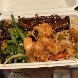a hand holding a container of food
