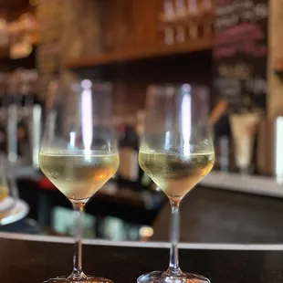 two glasses of wine on a bar