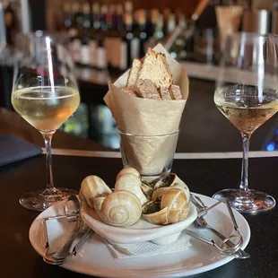 a glass of wine and bread on a plate