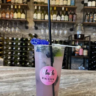 a pink drink with a straw and a blue flower