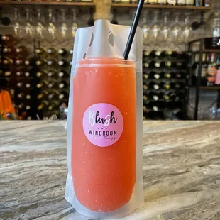a pink drink with a black straw
