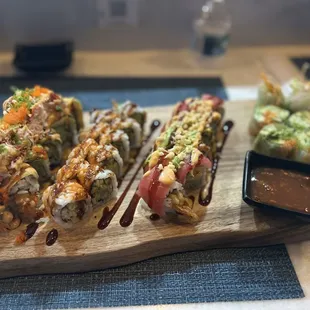 sushi rolls on a cutting board with dipping sauce