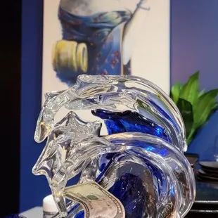 a glass sculpture of a woman and a dragon