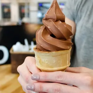 a person holding an ice cream cone