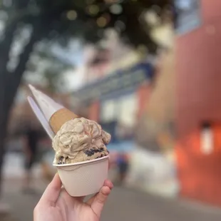 a hand holding an ice cream cone