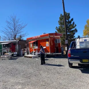 a woman standing in front of a food truck