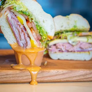 a sandwich being drizzled with mustard