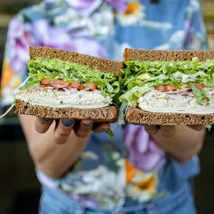 a person holding a sandwich