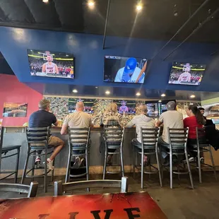 multiple tvs displaying live games for baseball and basketball