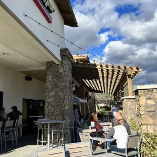 a man sitting at a table outside a restaurant