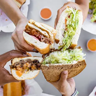 hands holding sandwiches