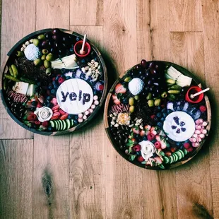two trays of food on a wooden floor