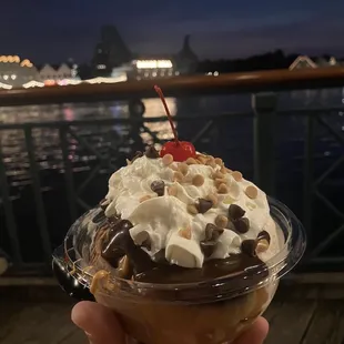 a hand holding a cup of ice cream