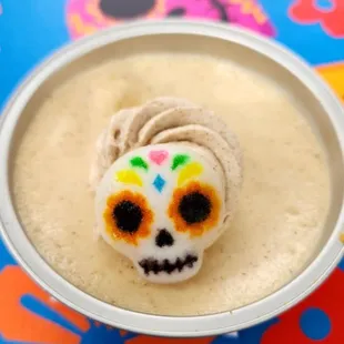 a bowl of cheesecake with a sugar skull on top