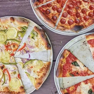 three different pizzas on a table