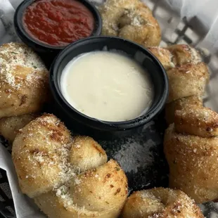 a basket of doughnuts with dipping sauce