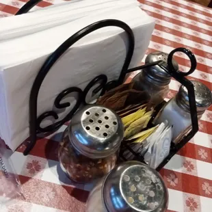 a napkin, salt and pepper shakers on a checkered tablecloth