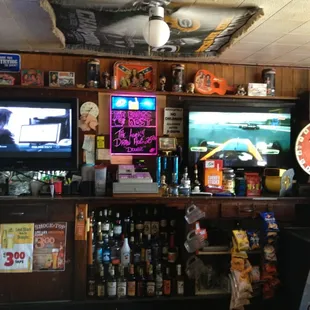 a bar with a television and various liquors