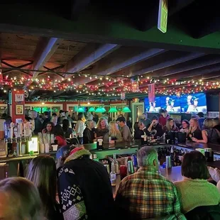 a large group of people sitting at the bar
