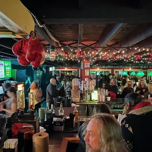 a crowded bar with people sitting at tables