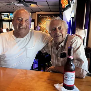 two men sitting at a bar