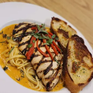 a plate of pasta and grilled chicken